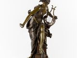 a bronze statue of a woman holding a harp