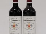 two bottles of red wine sitting next to each other on a table