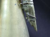 a silver vase with a ring on top of it