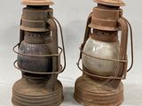 two old lanterns sitting next to each other on a table