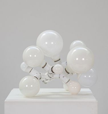 une image d'une sculpture composée de boules de verre posées sur un socle blanc