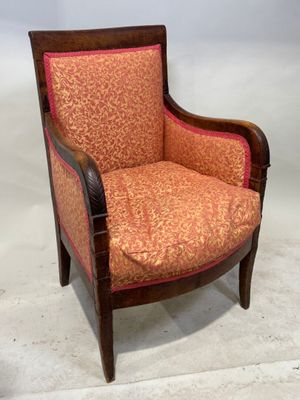 une image représentant une chaise en bois dont l'assise est recouverte d'un tissu rouge et orange