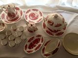 a lot of red and white dishes and cups on a table