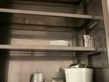 a stainless steel cabinet with shelves above a sink