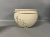a white bowl with a drawing on it on a table