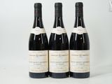 trois bouteilles de vin sont alignées sur une surface blanche
