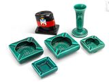 quatre cendriers verts posés sur une surface blanche