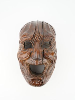 an image of a wooden mask on a white surface with a white background