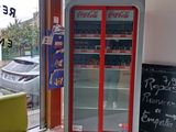 a coca cola machine in the corner of a store