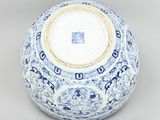 a blue and white vase with a gold rim on it