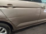 a brown car parked in a garage with its door open