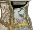 a vase that has a gold and white decoration on it