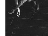 black and white photograph of a naked woman laying on the floor