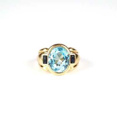 Gros plan sur une bague en or ornée d'une topaze bleue
