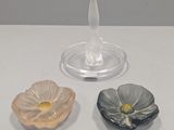 three small flower shaped dishes on a table
