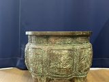 a large bronze urn sitting on top of a wooden floor