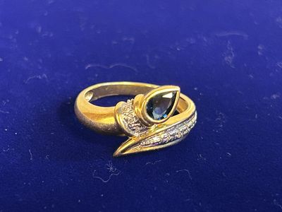 a close up of a gold ring with a green stone on it