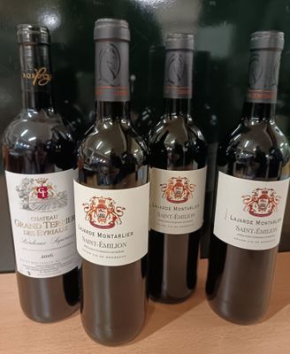 six bouteilles de vin rouge sont alignées sur une table