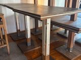une table en bois avec deux bancs au milieu de la pièce