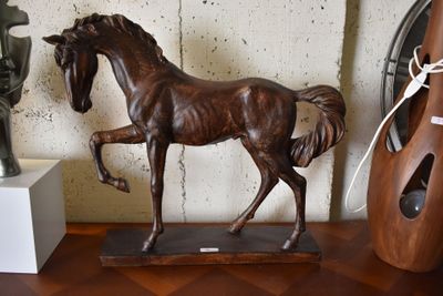 a statue of a horse on a table next to a vase