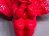 a red angel figurine sitting on top of a table