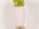 a pink vase with flowers in it on a white surface