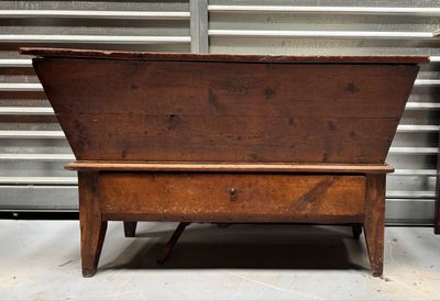 an old wooden bench that is sitting in front of a metal wall