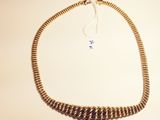 gold plated chain necklace with a tassel on a white background