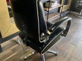 a black chair that is in a room with a book shelf