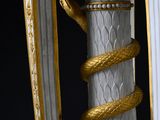 un vase blanc et doré surmonté d'un serpent