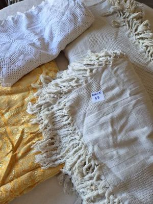 a white blanket and a yellow blanket on a bed