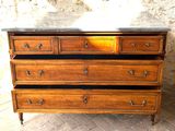 a wooden chest of drawers with a marble top