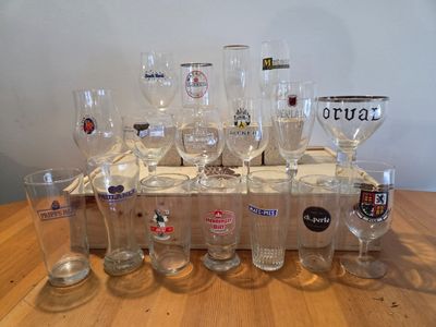 bottles and glasses are lined up on a wooden tray on a table