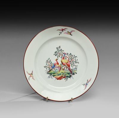 une assiette blanche ornée d'un motif représentant un oiseau et des fleurs