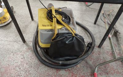 un sac posé par terre à côté d'un aspirateur