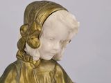 a statue of a little girl that is wearing a hat