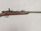 un fusil avec un canon en bois sur fond blanc