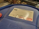 a blue barrel with a red handle and a tag on it