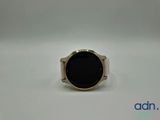 a close up of a ring with a black stone on it
