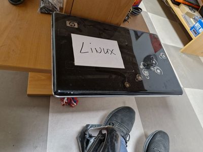 a laptop that is sitting on the floor with a sign on it