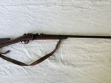 le fusil est posé sur un lit recouvert d'un drap blanc