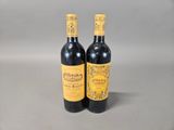two bottles of wine sitting next to each other on a table