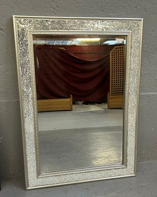 un miroir posé sur le sol devant un mur