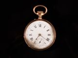 une montre de poche en or avec des chiffres romains sur le cadran