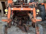 un tracteur équipé d'une charrue, dans une grange