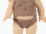 a small doll with blonde hair and a brown outfit