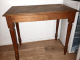 a small table with a wooden top in the corner of a room