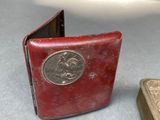 a small red book with a gold cover next to a smaller red book