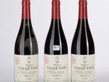 trois bouteilles de vin rouge posées sur une table blanche
