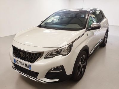 Une voiture blanche est garée dans une grande pièce au sol blanc.